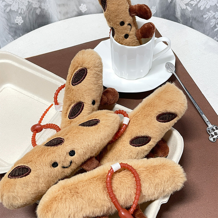 Group of baguette plush keychains arranged around a white cup and saucer
