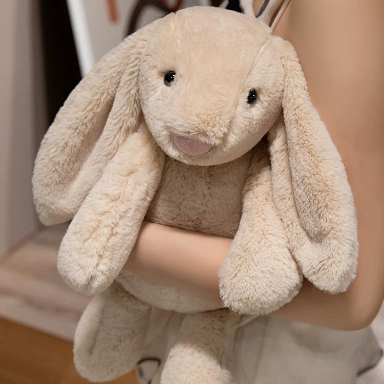 Beige lop-eared bunny plush lovingly hugged in arms, symbolizing emotional comfort and softness.