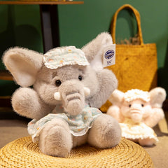 Bruce Comfort Sitting Elephant Plush Toy in a blue bonnet, exuding gentle companionship and warmth on a woven mat.