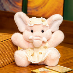 Pink Bruce Comfort Sitting Elephant Plush Toy wearing a dress, softly posed on a wooden surface, evoking comfort.