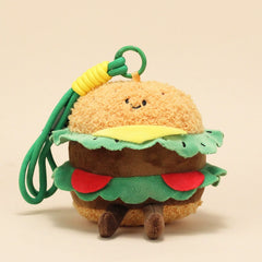 Front view of burger plush keychain with lettuce, cheese, and a cheerful face