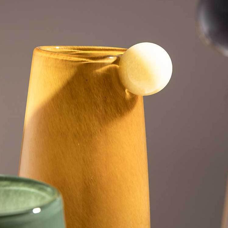 Close-up detail of bubble accent on amber glass vase, showcasing artisan craftsmanship and unique tactile finish.