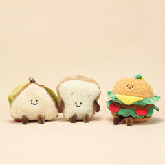 Close-up of sandwich, bread slice, and burger plush keychains highlighting their embroidered faces