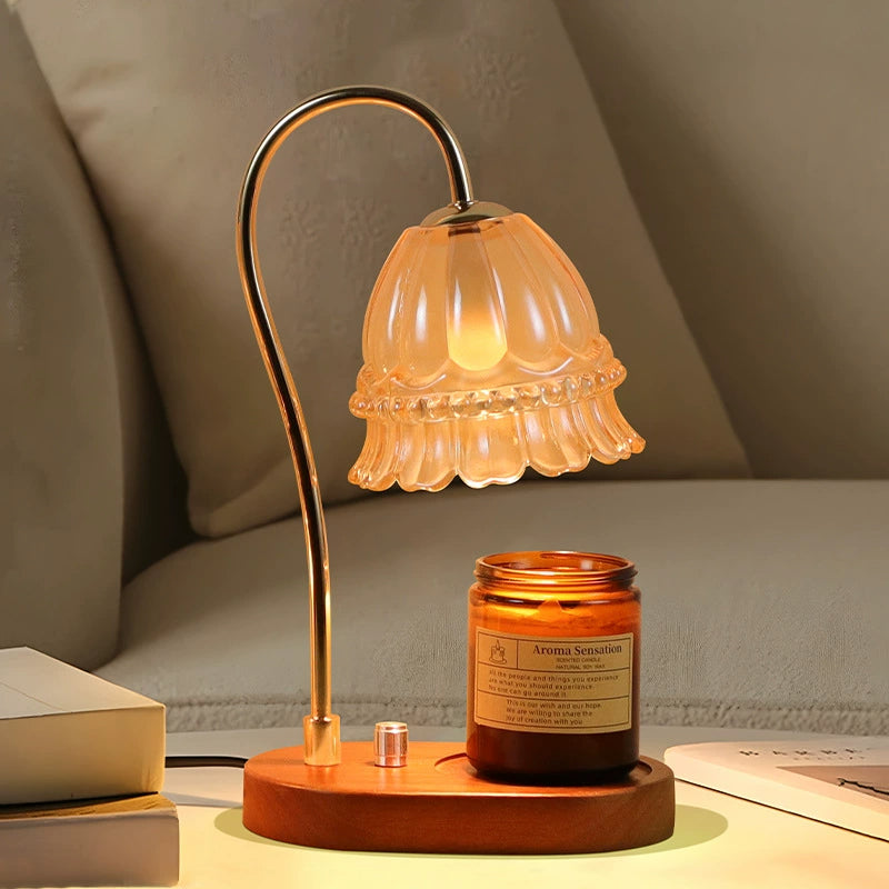 Elegant candle warmer with lily of the valley design glowing beside a sofa, enhancing the home’s comforting atmosphere