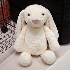 Cream-colored lop-eared bunny plush calmly seated, radiating peacefulness and tactile softness.