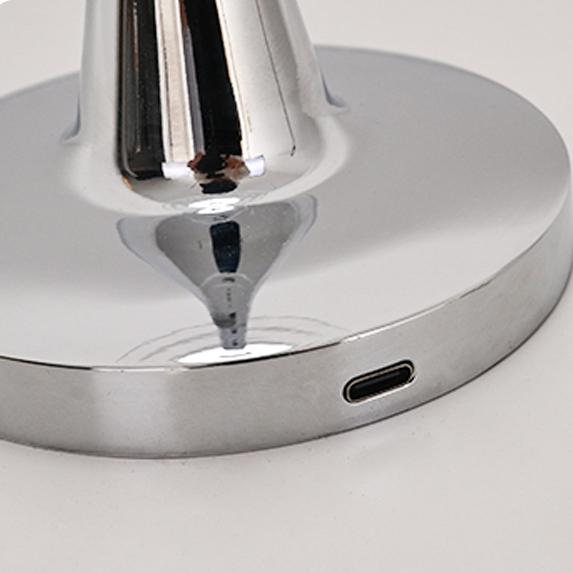 Detailed view of the lamp's polished base featuring the USB charging port, showing the lamp's modern finish.