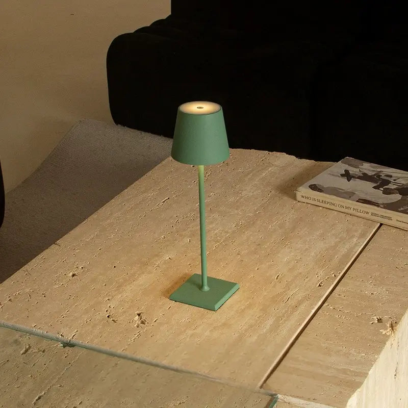 Green desk lamp centered on wooden table, creating a cozy modern vibe