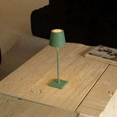 Green desk lamp centered on wooden table, creating a cozy modern vibe