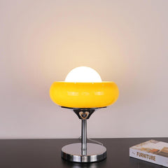 Illuminated yellow retro desk lamp on modern black table, radiating soft, harmonious light