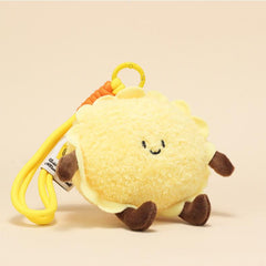 Side view of egg tart plush keychain with cheerful face and yellow clip