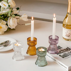Elegant glass candle holders with candles, set amidst fine dining decor for refined ambiance