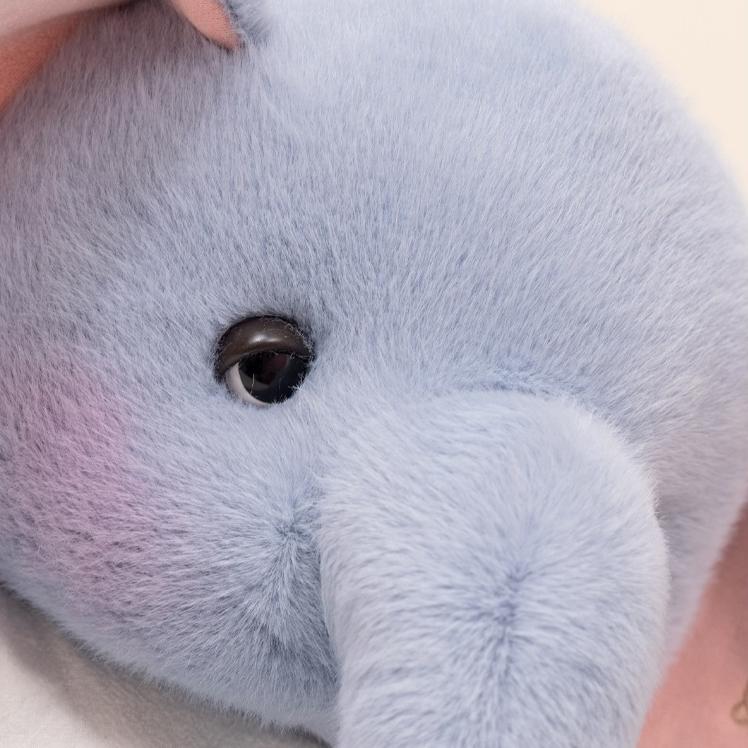 Close-up of the elephant plush toy showing its delicate eye and smooth, velvety fabric