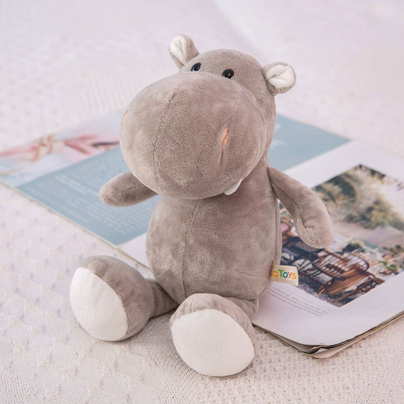 Soft hippo plush toy with gentle expression sitting on a book, highlighting the touchable comfort of Plush Toys