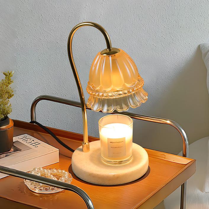 Delicate candle warmer lamp with floral design on a bedside table, softly casting light with a white scented candle