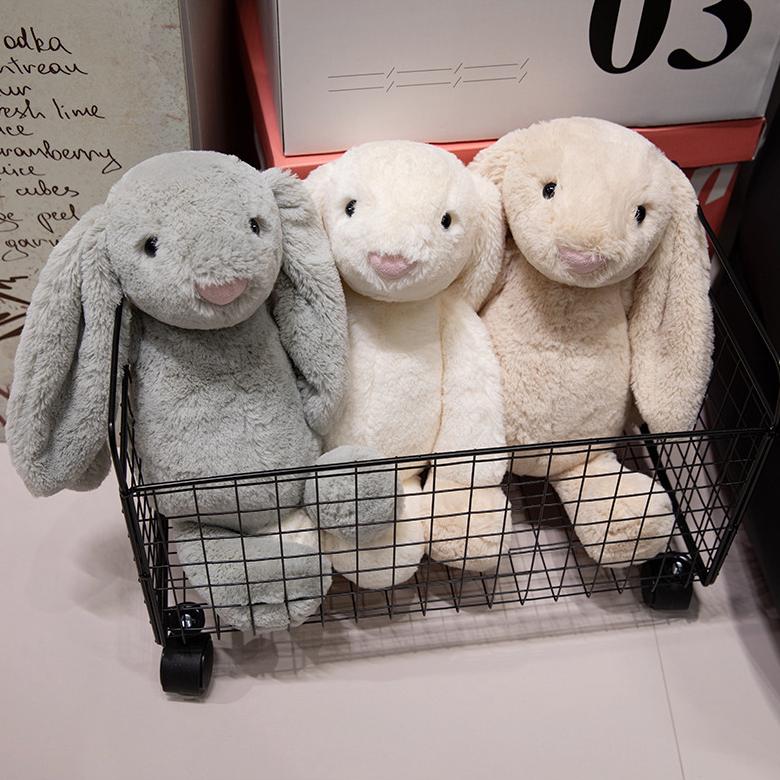 Trio of plush lop-eared bunny toys in a wire basket, ready to bring warmth to your space.