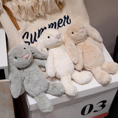 Three plush lop-eared bunny toys in gentle gray, cream, and beige colors displayed together for comfort seekers.