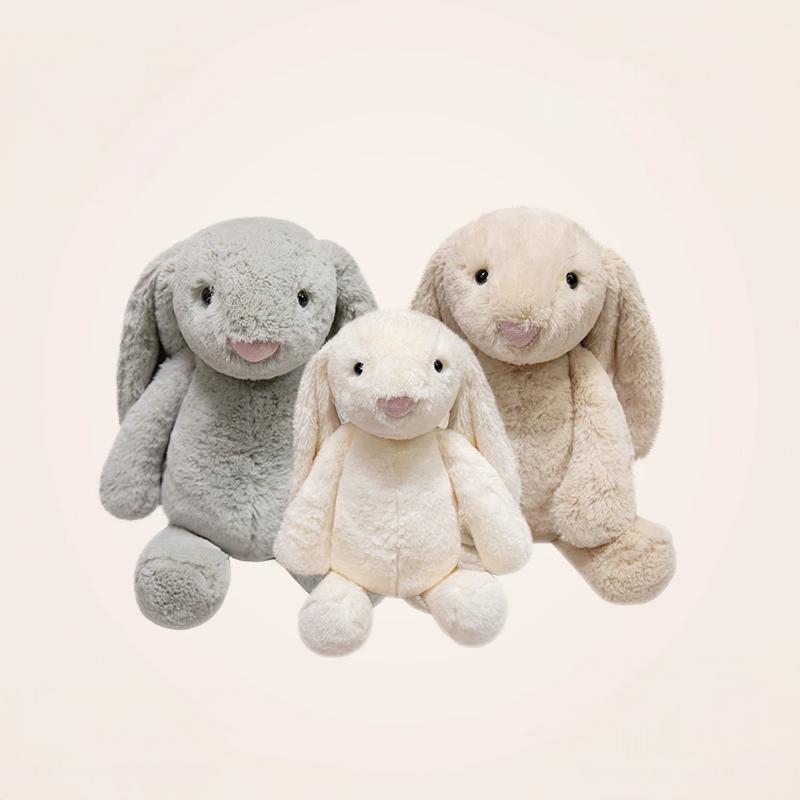 Three lop-eared bunny plush toys resting on a chair, offering feelings of serenity and companionship.
