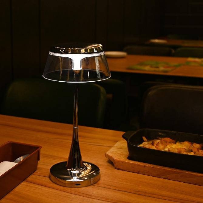 The lamp enhancing a dining table’s atmosphere with its sleek and minimalist design in a restaurant setting.