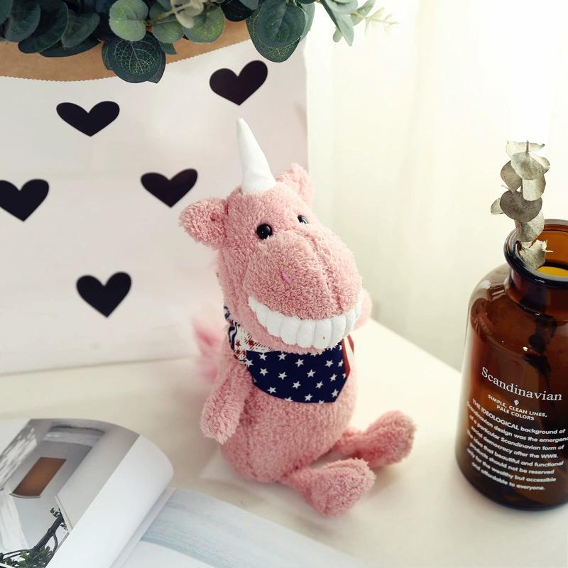 Pink plush toy with a wide smile and star-patterned scarf, placed next to a vase and heart decor