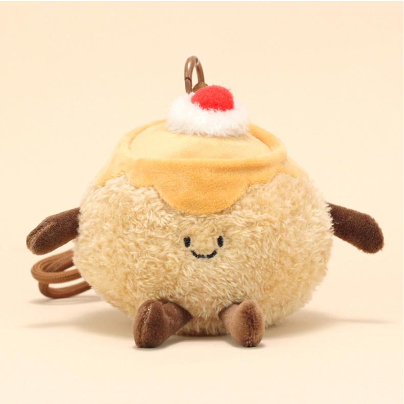 Front view of pudding plush keychain with happy expression and decorative cherry