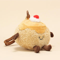 Side view of pudding plush keychain with smiling face and cherry on top