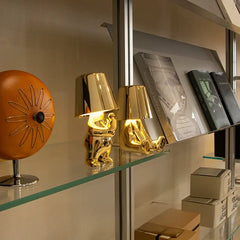 Soulster Lamps in gold and silver displayed on glass bookshelves, highlighting a modern minimalist lifestyle