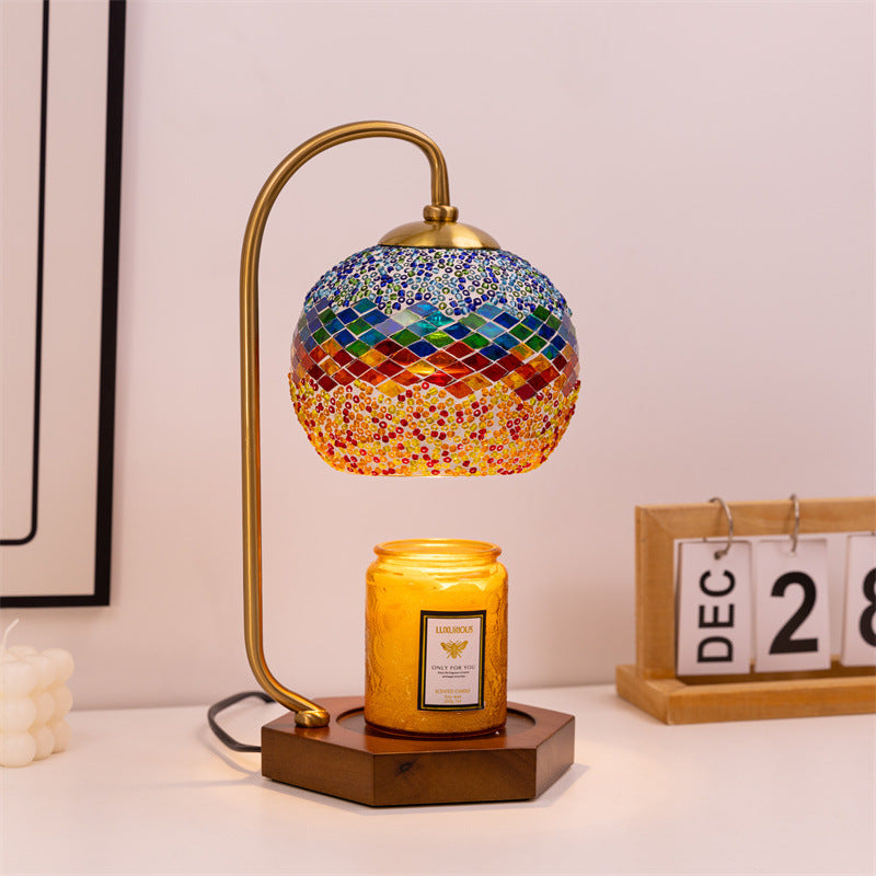 The vintage candle warmer lamp with stained glass shade illuminating a cozy setting with candle