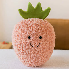 Soft pink strawberry plush toy with a green leafy top and a smiling face