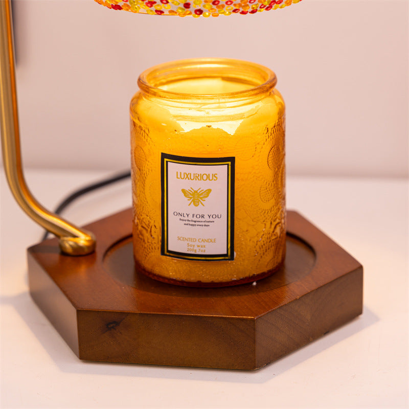 Detail of the candle warmer’s wooden base holding a luxurious scented candle