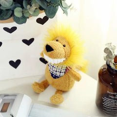 Yellow plush lion toy with big white teeth and gingham scarf, next to a brown bottle and heart art