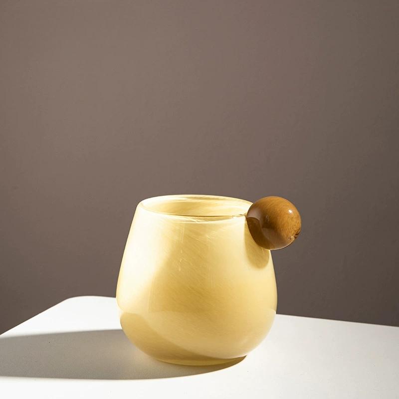 Chic yellow glass vase featuring a brown decorative bubble, perfect as a stylish planter or standalone decor piece.