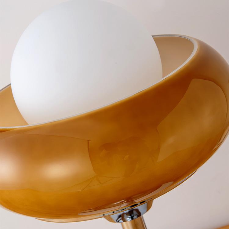 Close-up of yellow glass donut shade and white globe bulb, emphasizing unique retro design