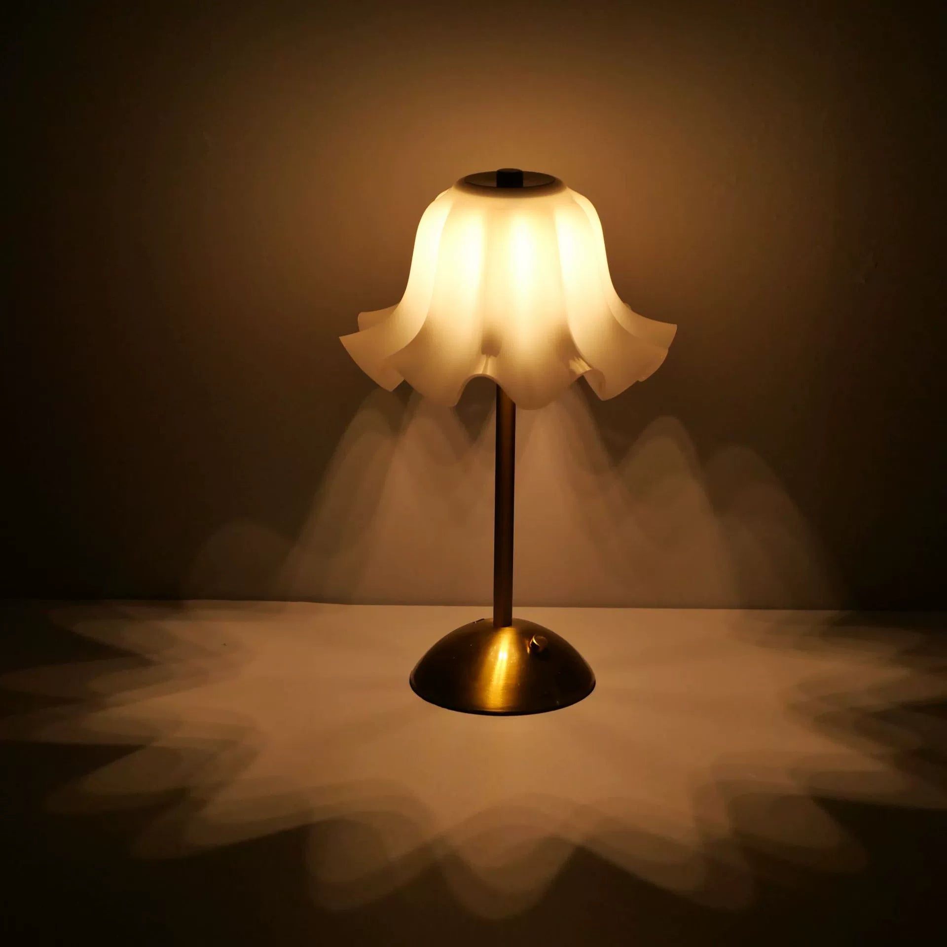 The petal desk lamp providing a deep, ambient glow in a softly lit room, perfect for moments of peaceful contemplation or creative inspiration.