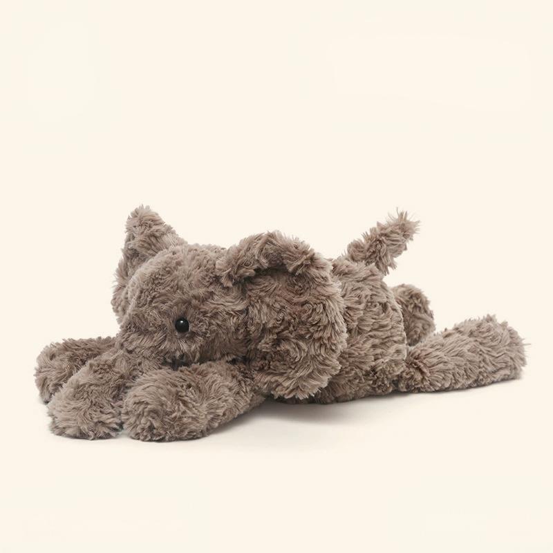 Diagonal angle of elephant animal laying plush, blending soulful eyes and delicate plush