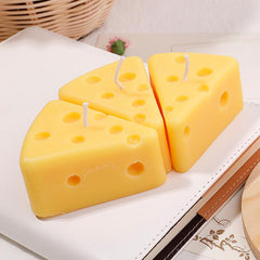 Three wedge-shaped cheese candles arranged together, vibrant and playful decorative candles.