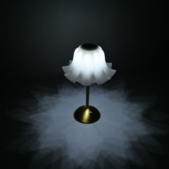 The flower-shaped desk lamp shown with its cool white light setting, casting a crisp, star-like pattern that inspires clarity and focus.