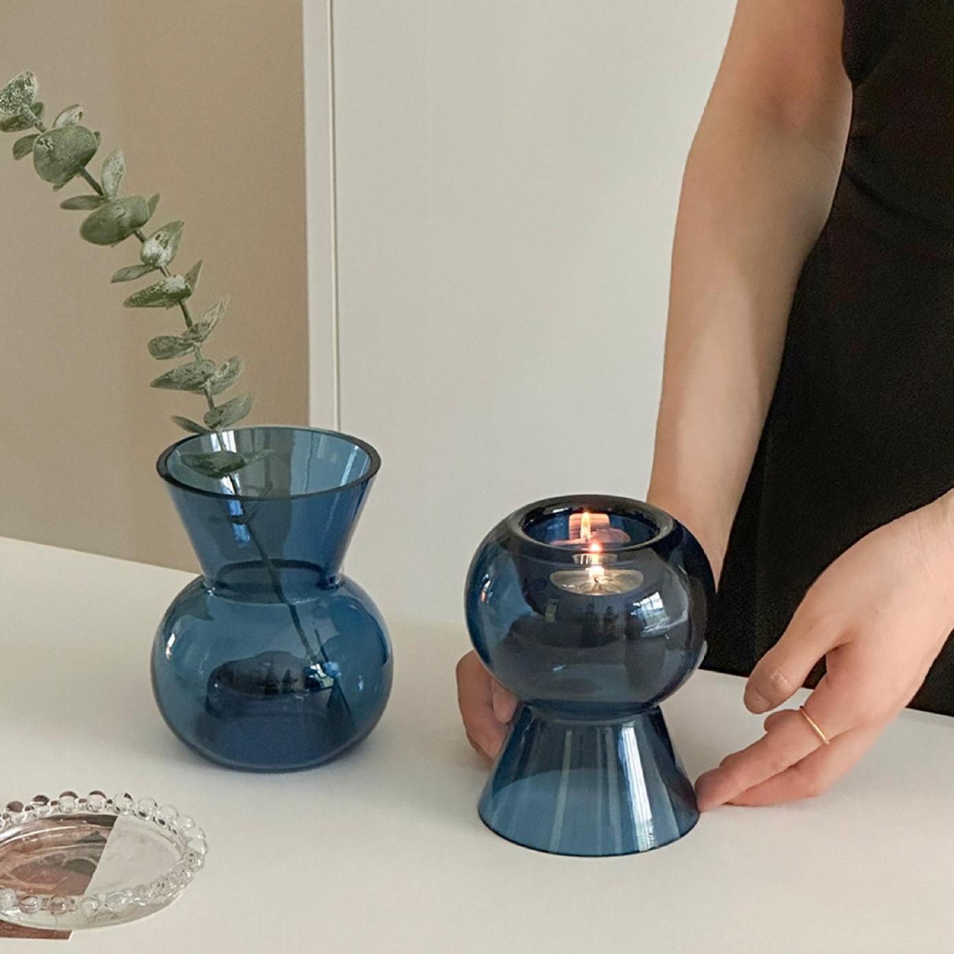 Blue glass candle holder and vase with hand adjusting set, showing everyday versatility.