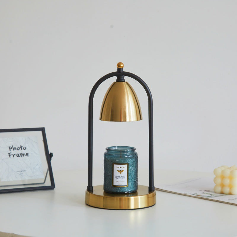 Gold vintage candle warmer lamp beautifully paired with a blue candle, perfect for cozy and nostalgic spaces.