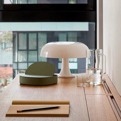The minimalist Mushroom Desk Lamp sits elegantly on a sunlit wooden desk, embodying modern design and adding a touch of serene focus to the workspace.