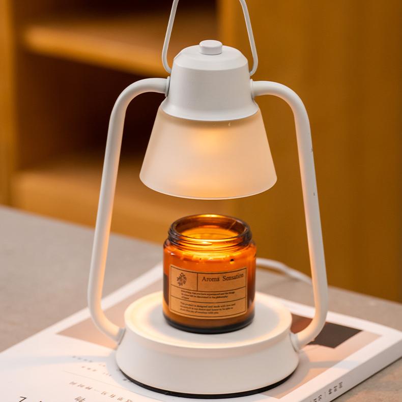 Softly glowing white candle warmer lamp with modern minimalist lines and scented candle