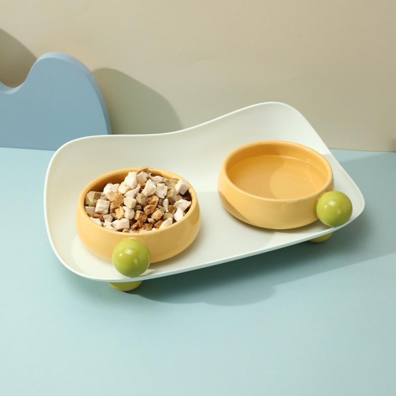 Yellow Sugar Bean Ceramic Cat Bowls with water and freeze-dried snacks on blue table