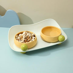 Yellow Sugar Bean Ceramic Cat Bowls with water and freeze-dried snacks on blue table