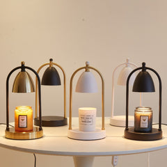 A collection of vintage romantic candle warmer lamps in different finishes, displayed on a round table, showcasing minimalist and elegant design.