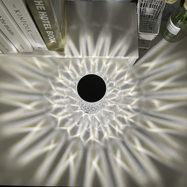 Overhead view of the Water Ripple Aurora Decorative Lamp radiating intricate crystal wave patterns across a modern white desk surface.