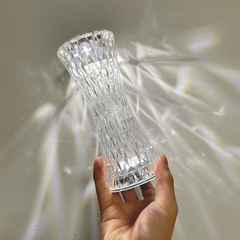 Hand holding the Water Ripple Aurora Decorative Lamp with its transparent chic design illuminating gentle ripples on the wall.