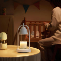 White vintage candle warmer lamp subtly lighting a scented candle in a nursery, fostering a gentle, safe atmosphere.